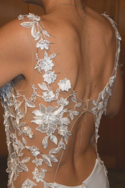 Un tissu invisible de la couleur de la chaire accueil des motifs de dentelle en forme de fleur sur un dos de robe de mariée sur mesure